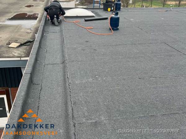 Dakdekker repareert bitumen dakbedekking op groot plat dak in Raamsdonksveer Dakdekker repareert bitumen dakbedekking op groot plat dak in Raamsdonksveer