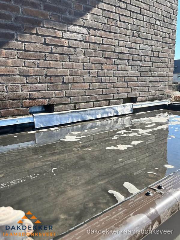 Stilstaand water op plat dak door slechte afwatering in Raamsdonksveer Stilstaand water op plat dak door slechte afwatering in Raamsdonksveer