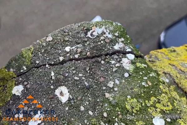 Beschadigde en verweerde nokvorst met scheuren en mos in Raamsdonksveer Beschadigde en verweerde nokvorst met scheuren en mos in Raamsdonksveer